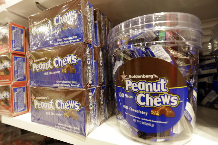 Boxes and tubs of a chocolate candy stacked on a shelf