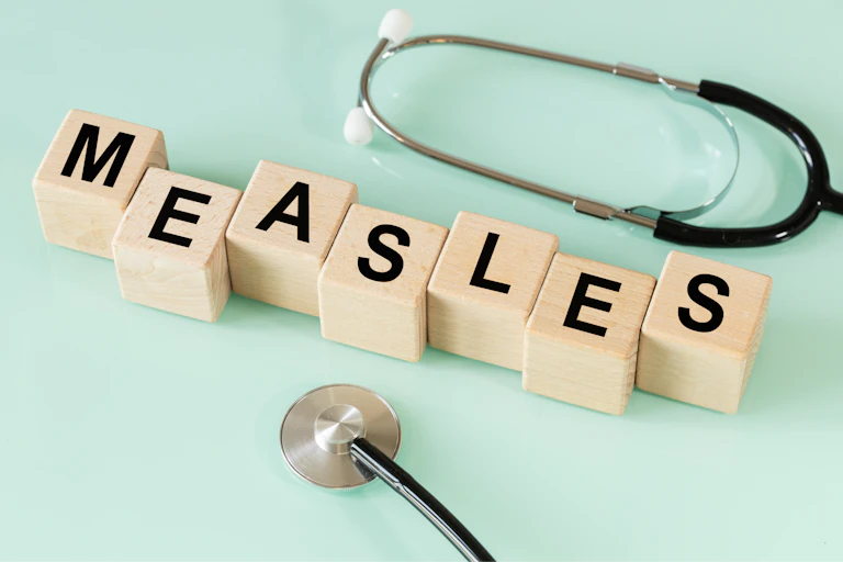 Wooden blocks spelling out measles, and a stethoscope