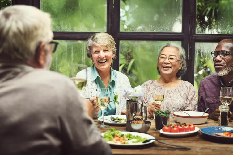 A group of people with grey sitting at a dining table
