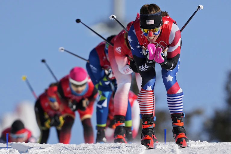 A row of female skiers races down a slope