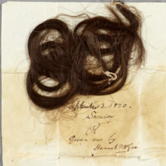 A dishevelled lock of hair on a piece of paper