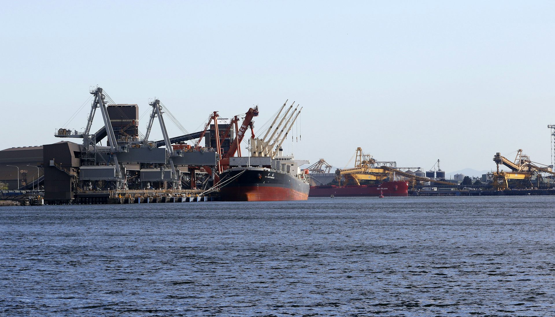 coal port, view of coal carrier, loader and ocean. 