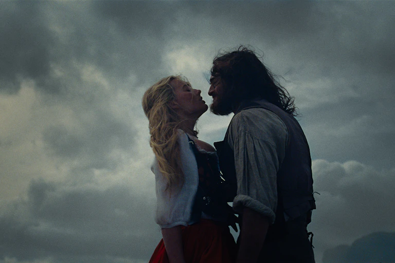 a brooding couple, a blonde woman and a long-haired man, against a stormy sky