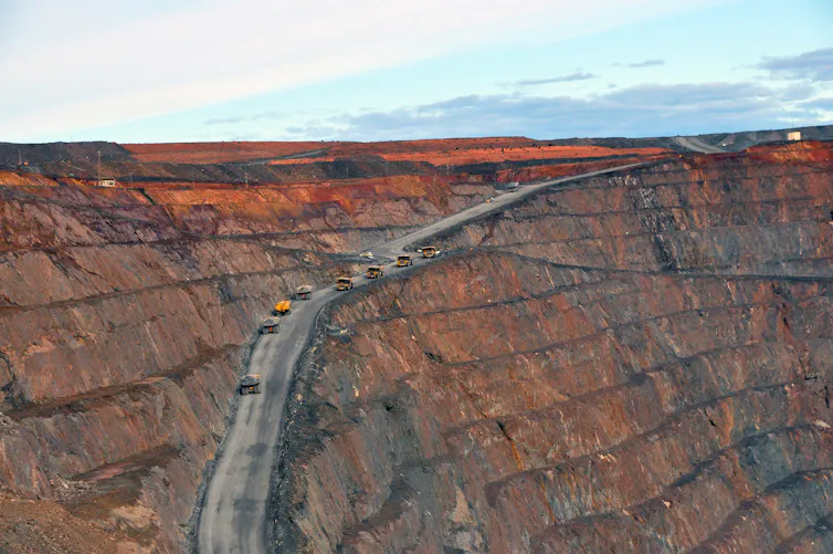 Cars travelling a carved-out rockface.