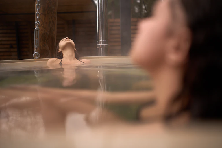 Two women relax in an indoor bath.