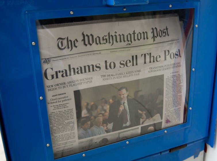 A copy of The Washington Post in a sales box has a big headline saying: 'Grahams to sell The Post.'