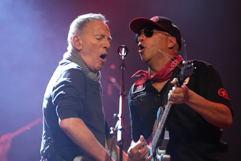 two men sing into a microphone