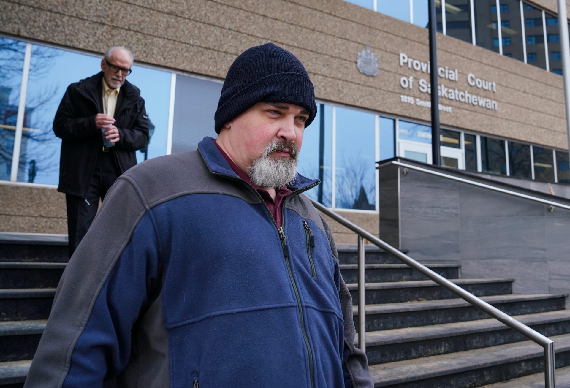Un hombre de barba gris sale del juzgado.