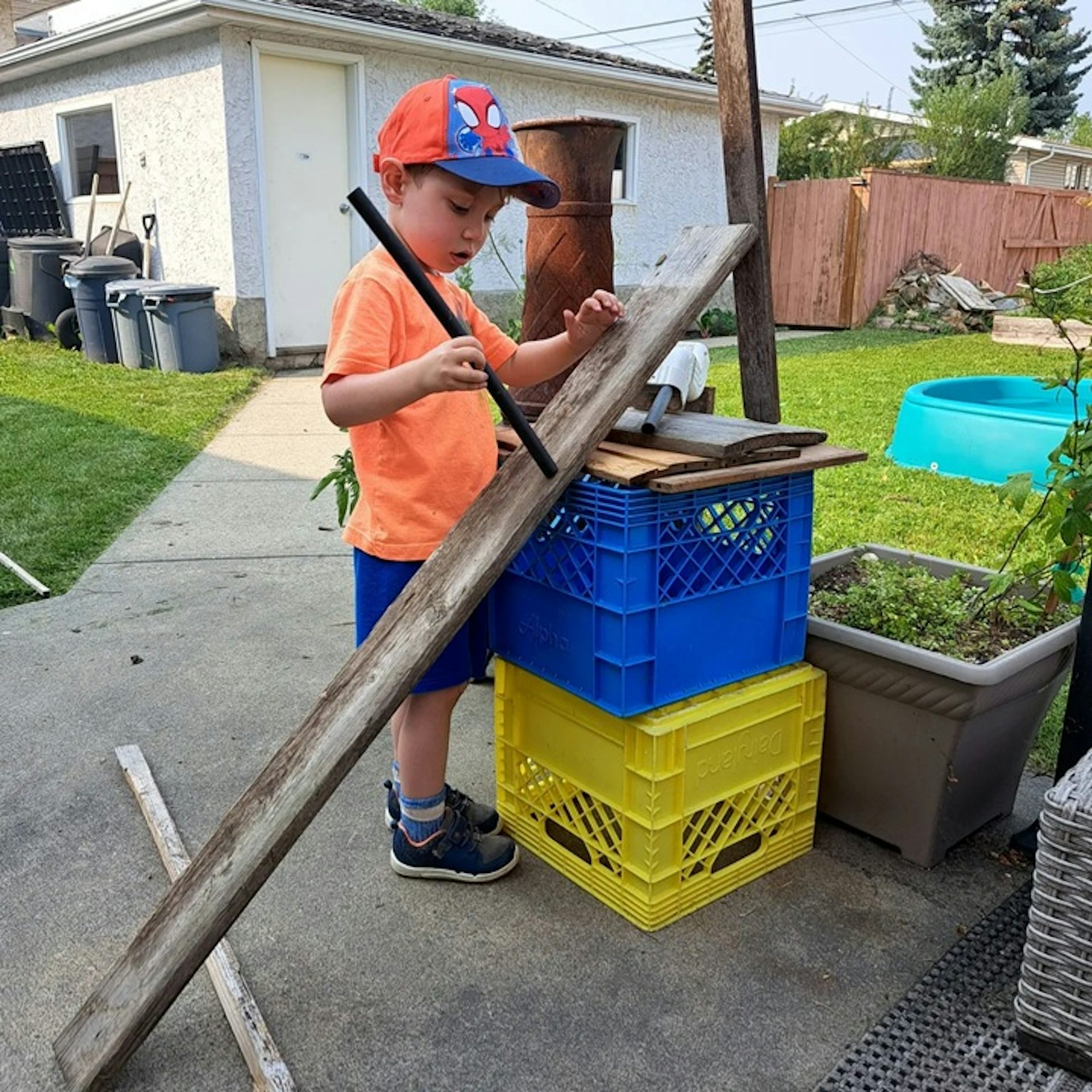 Niño de pie con rampa de madera y otros objetos.