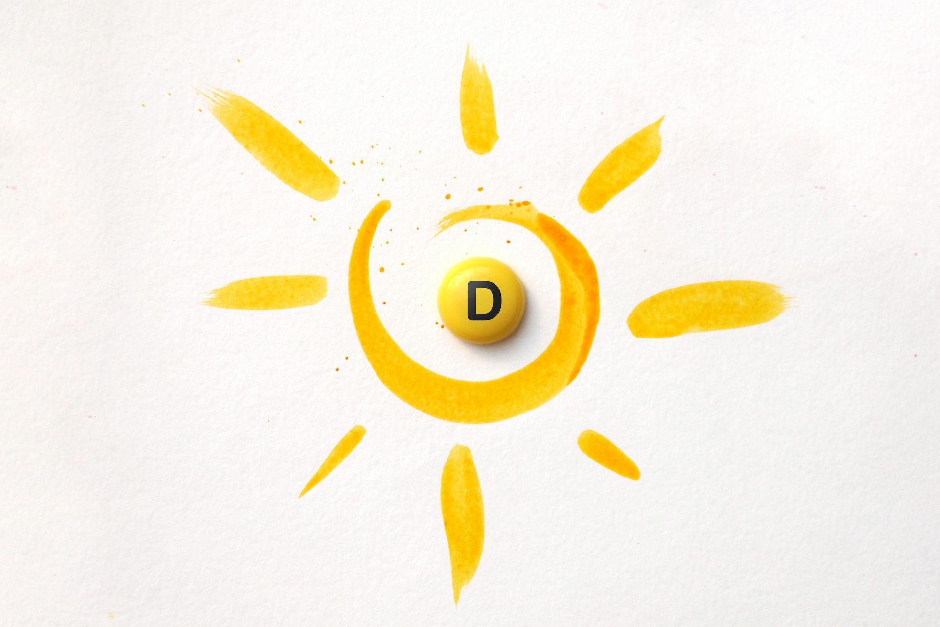 A tablet with the inscription Vitamin D in the centre of an illustration of the sun
