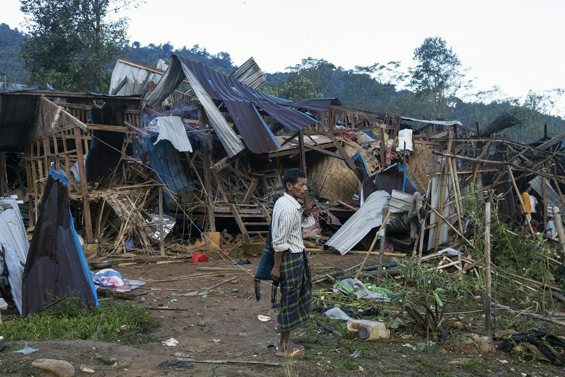 Un homme observe des habitations détruites