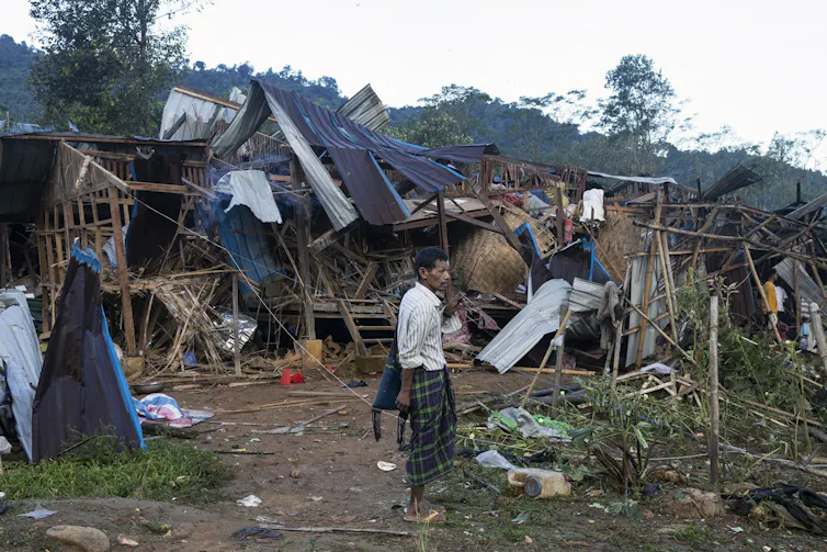 Un homme observe des habitations détruites