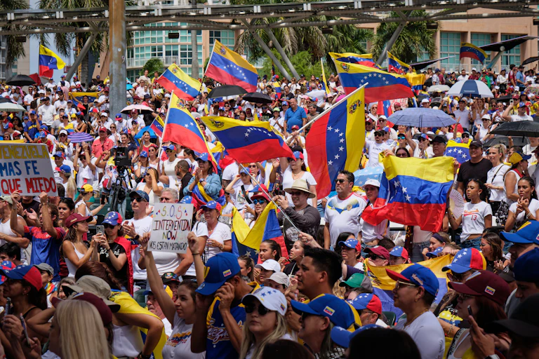 Yellow, blue and red flags are waved by a group of people.