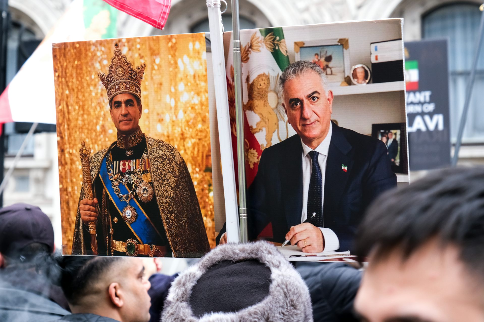 A group bearing loud posters of a man dressed in royal garb.