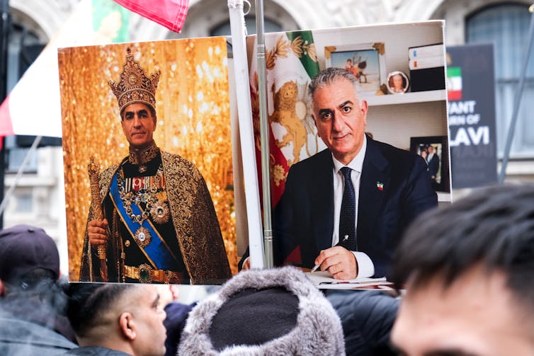 A group bearing loud posters of a man dressed in royal garb.