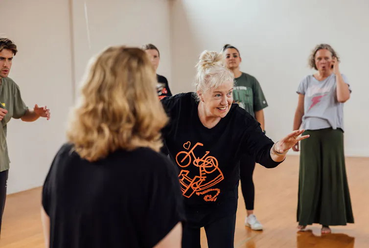 A woman with a smile runs a workshop.