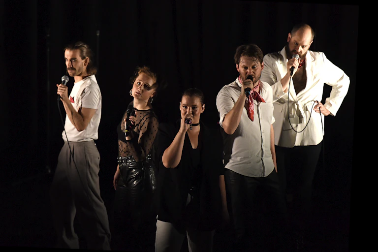 Five young actors with microphones.