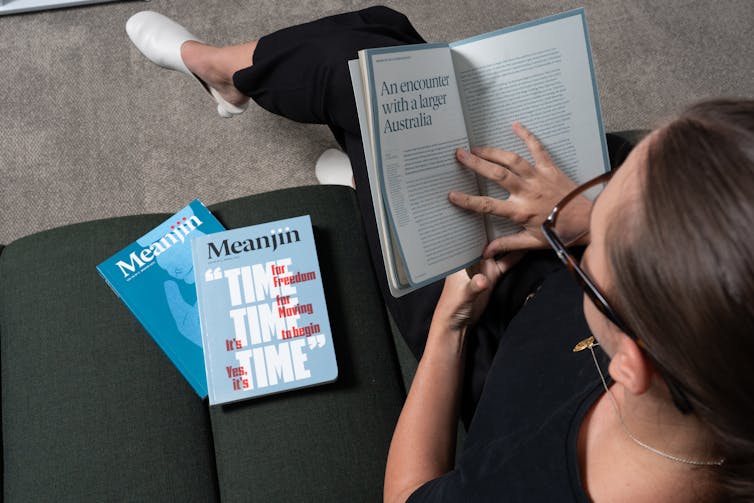 A woman reading issues of Meanjin