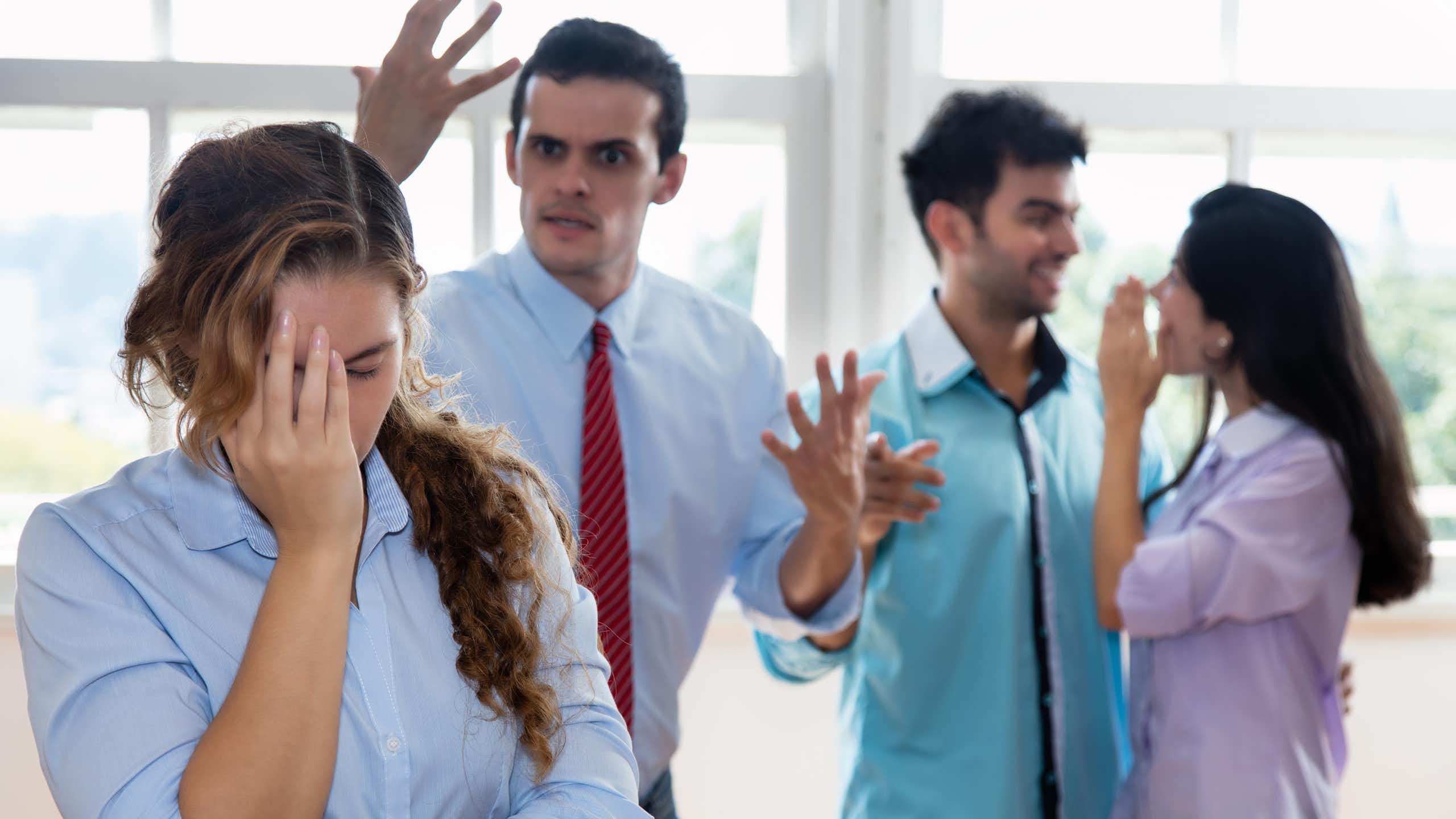 Employée la main sur sa tête avec son patron qui lui crie dessus