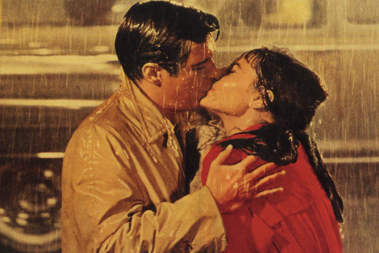 Audrey Hepburn and George Peppard kissing in the rain