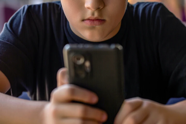 Un adolescente mira su móvil