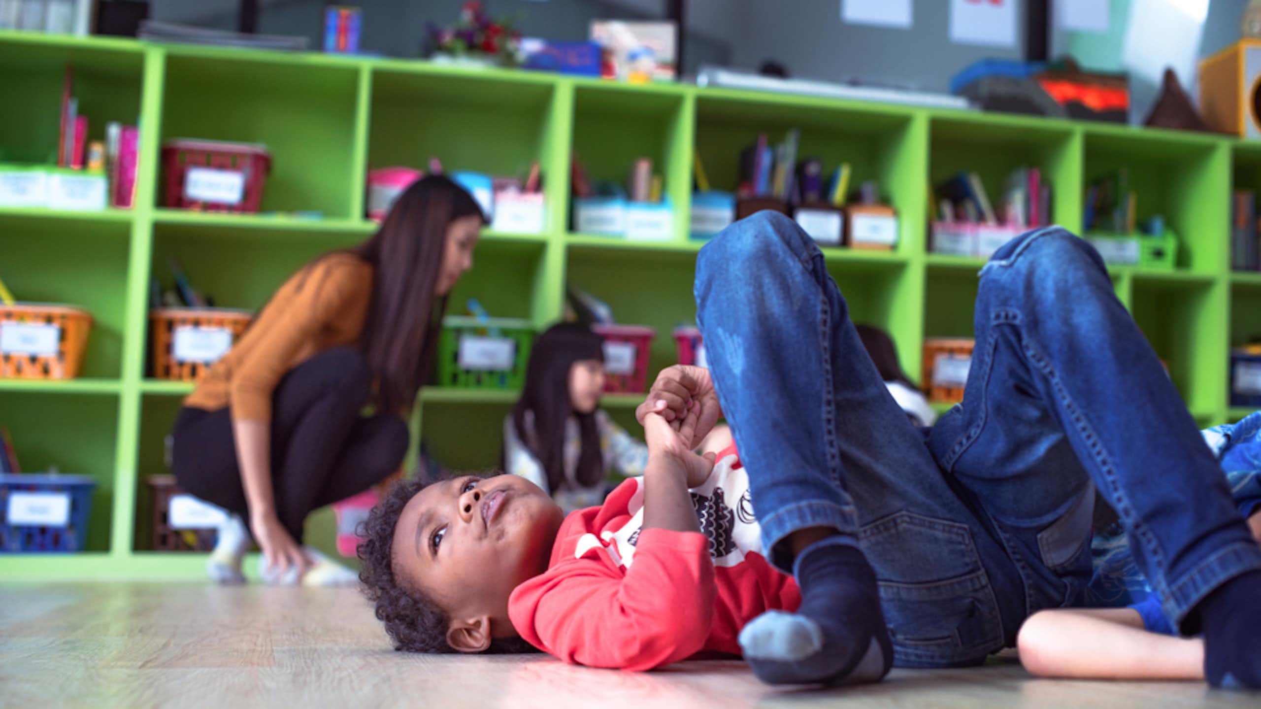 Un niño en el suelo dentro de un aula
