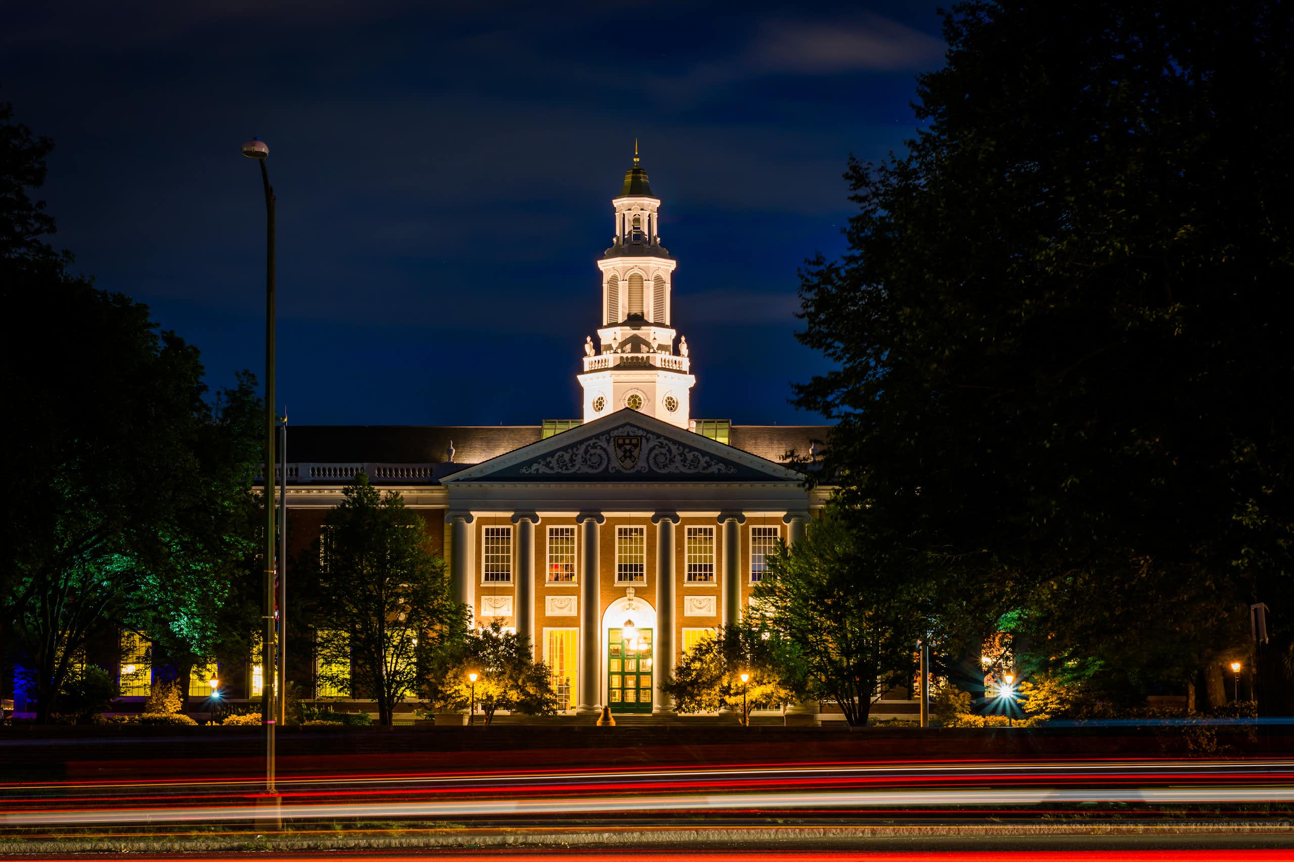 Circulation sur Soldiers Field Road et bâtiment à la Harvard Business School la nuit, à Boston, Massachusetts.