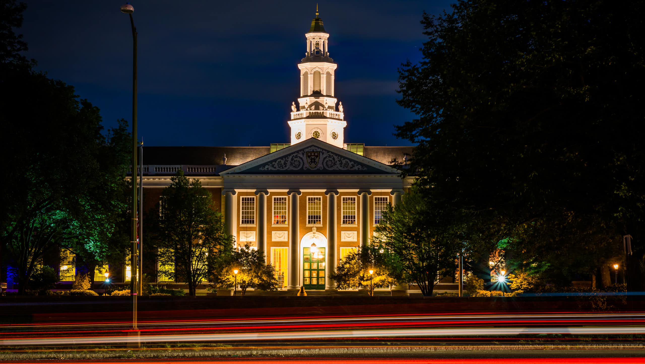 Circulation sur Soldiers Field Road et bâtiment à la Harvard Business School la nuit, à Boston, Massachusetts.