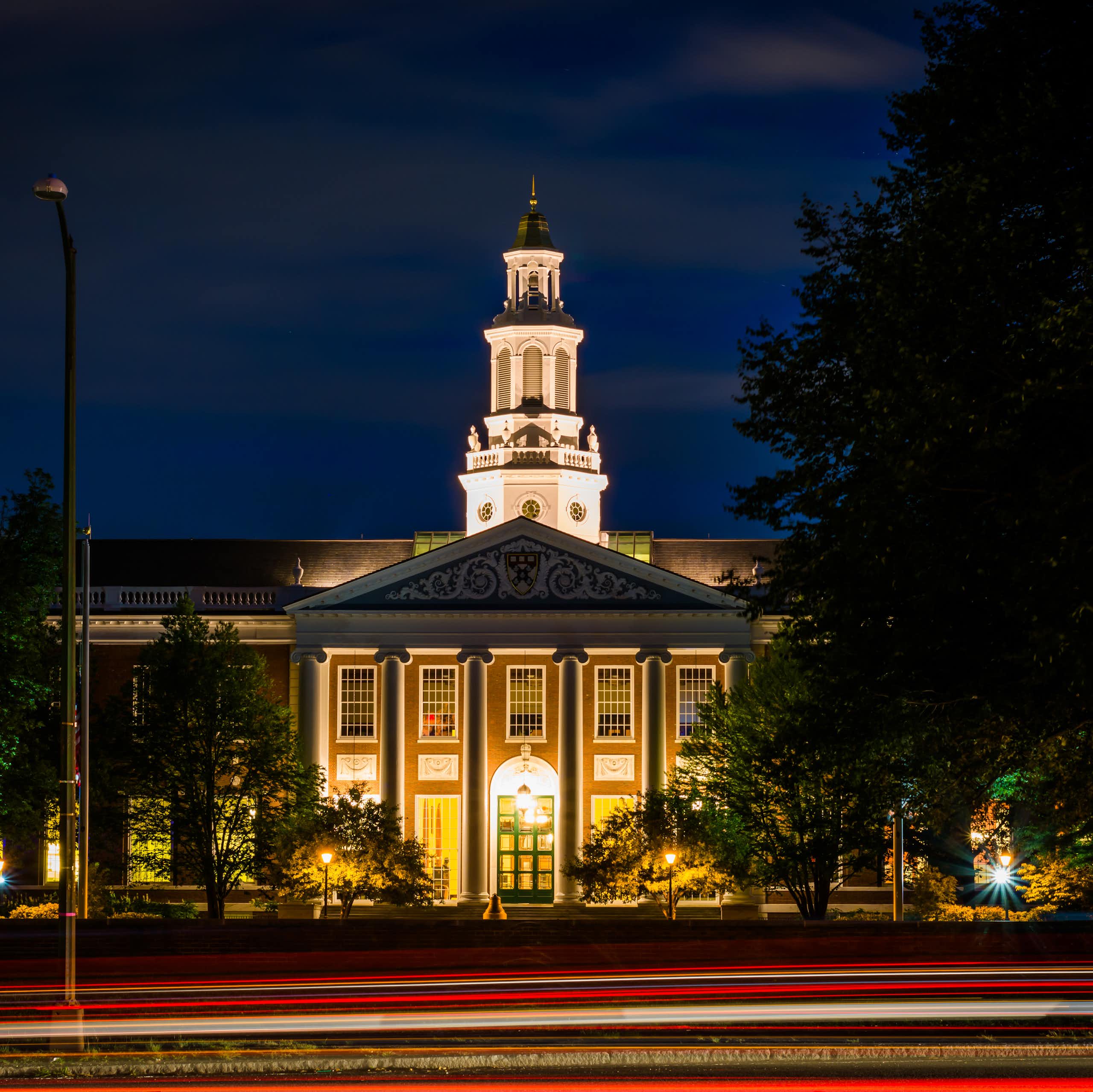 Circulation sur Soldiers Field Road et bâtiment à la Harvard Business School la nuit, à Boston, Massachusetts.