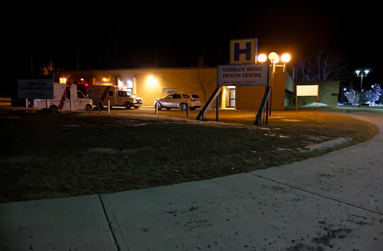Se pueden ver luces y una ambulancia detrƔs de un letrero que dice Tumbler Ridge Health Center.