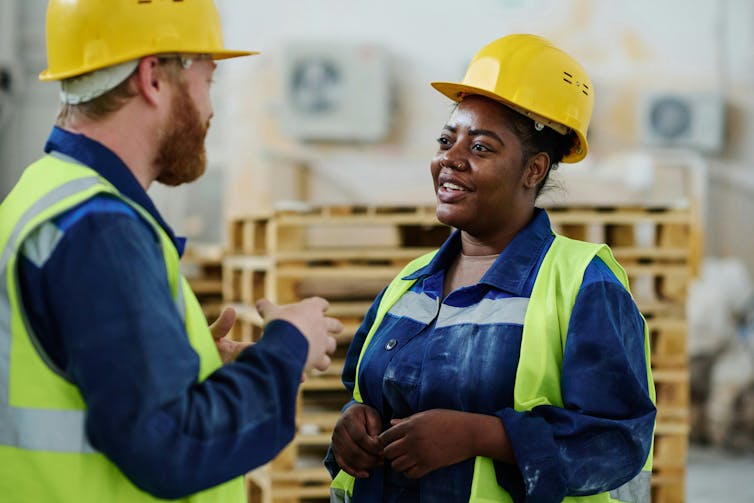 Qué significa realmente amar tu trabajo y cuándo ese amor puede convertirse en una obligación 1 Dos trabajadores de la construcción con cascos hablando sonriendo