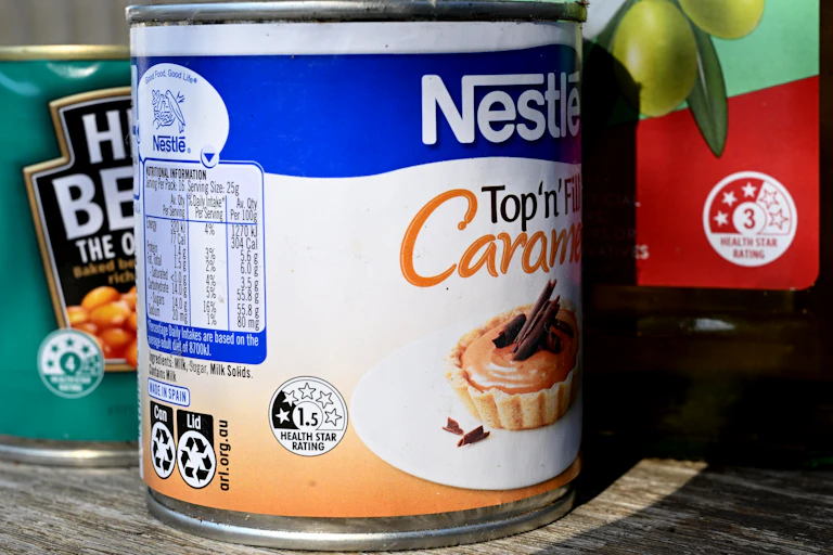A can of caramel sauce on a supermarket shelf.