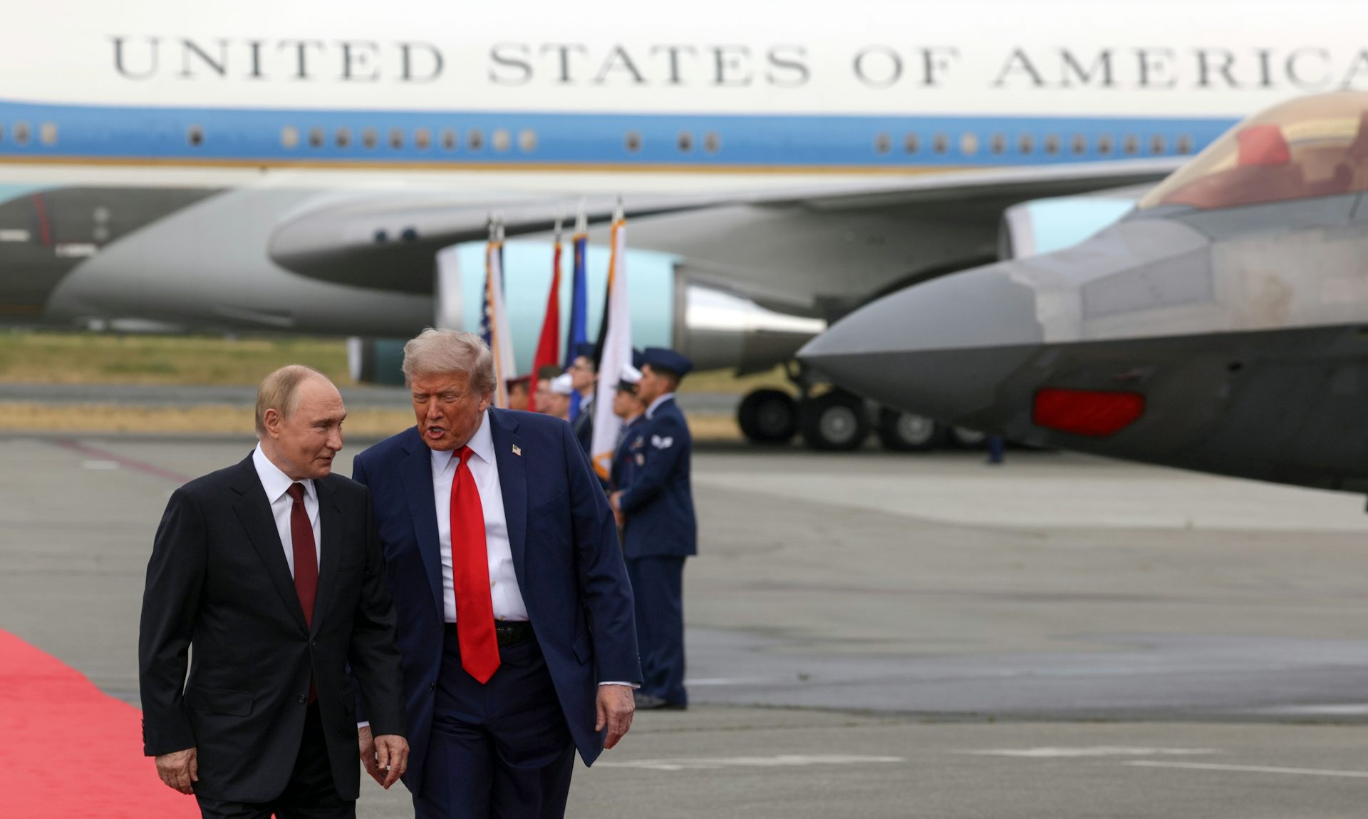 US president Donald Trump walks and talks with Russian president, Vladimir Putin. In the background is Air Force One.