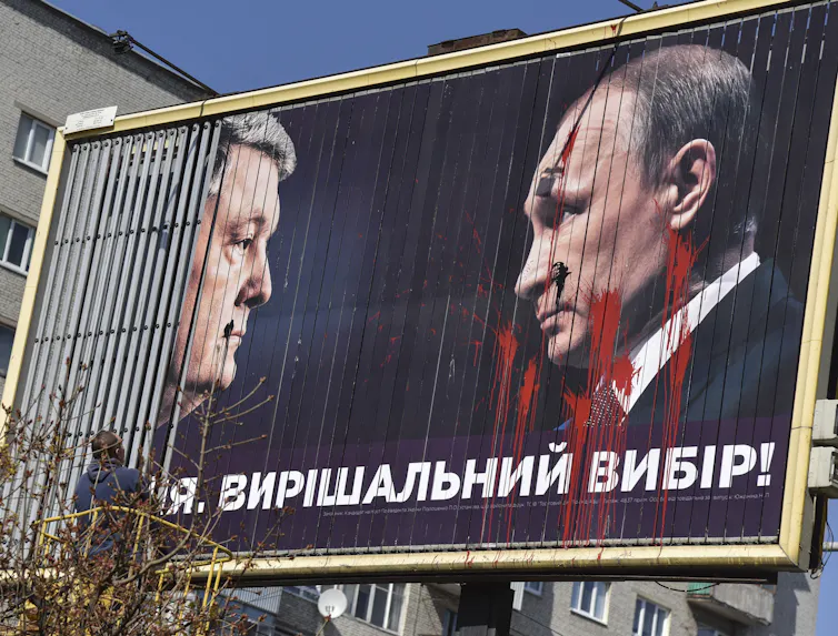 Ukrainian politician Petro Poroshenko faces Vladimir Putin on an election billboard in Ukraine, 2019.