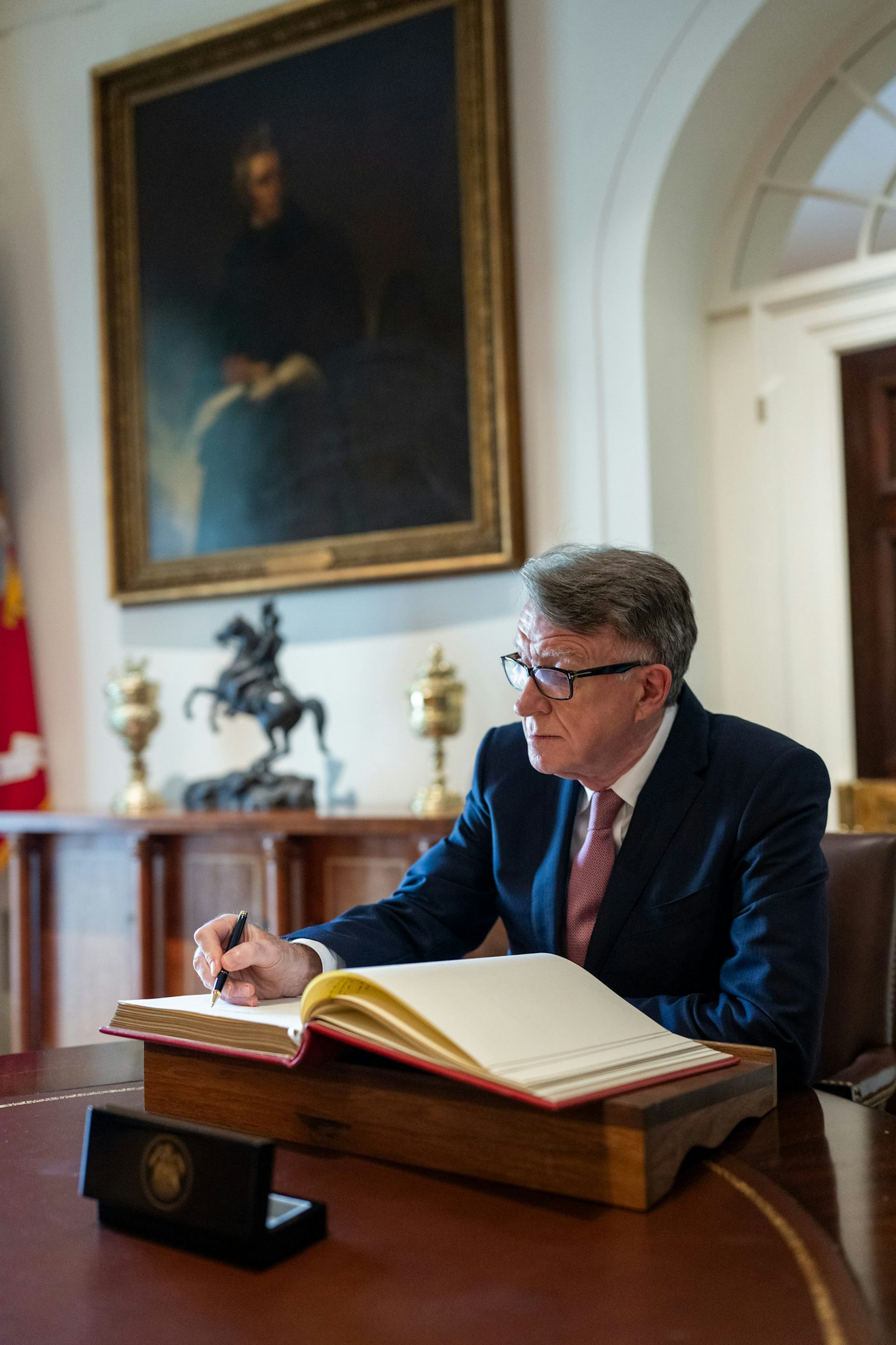 Peter Mandelson signing the White House guest book.