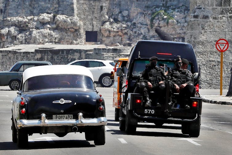 Cuban police sat in the back of a van.