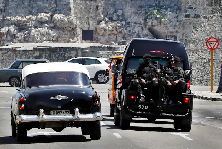 Cuban police sat in the back of a van.