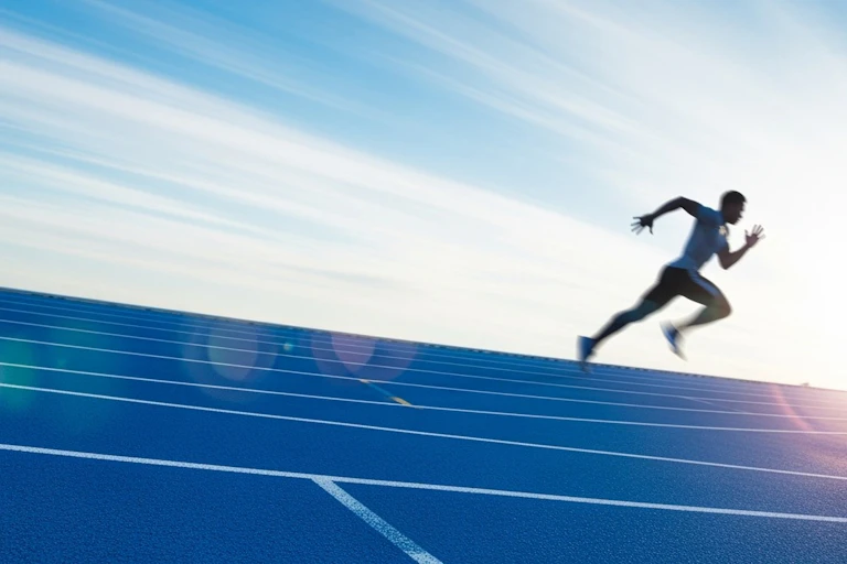 Athlete running on a track.