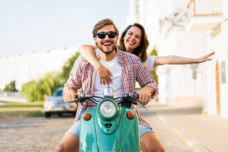 A young couple smiling on a motorbike