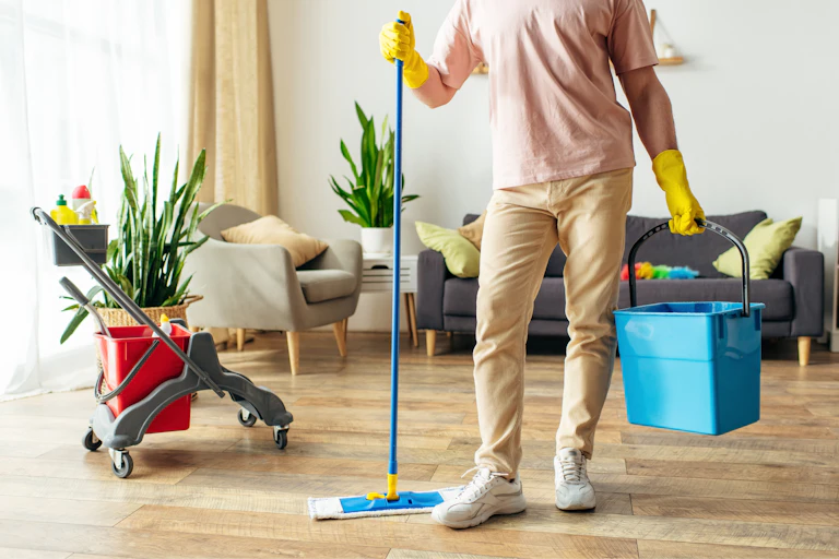 Man with a mop and bucket in a home