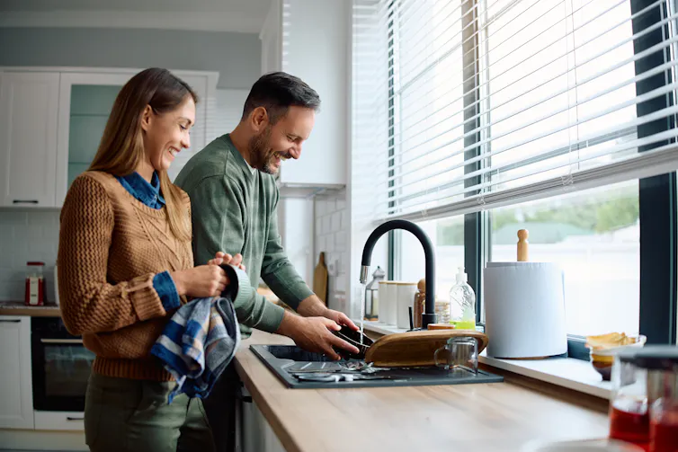 A man and woman do the dishes together