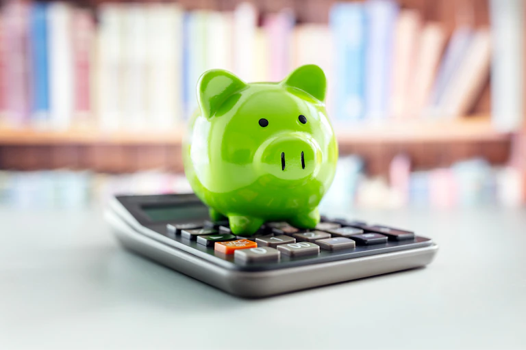 green piggy bank sat on calculator