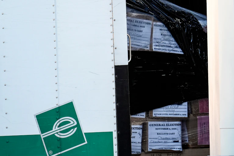 An enterprise trucjk with boxes of ballots in it.