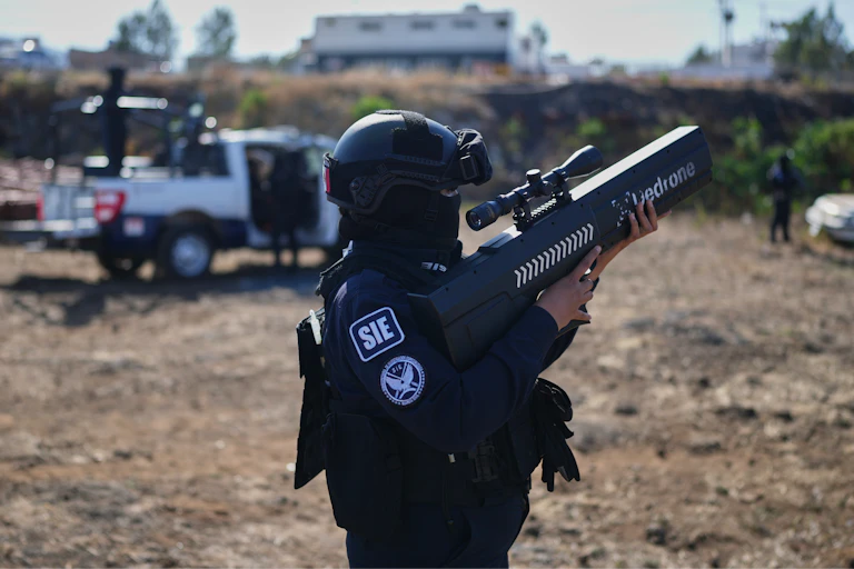 a person wearing a helmet and tectical gear holds a rifle-like weapon