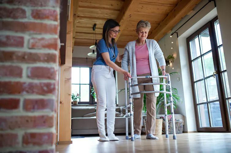 A health-care worker with a women using a walker