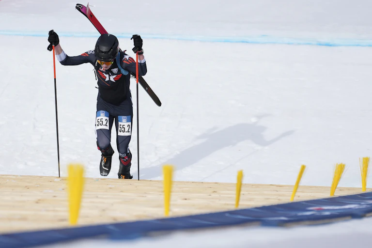 A skier climbs up a mountain