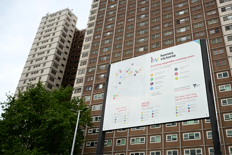 A Homes Victoria sign saying 'exciting upgrades coming soon' outside a public housing tower in Melbourne