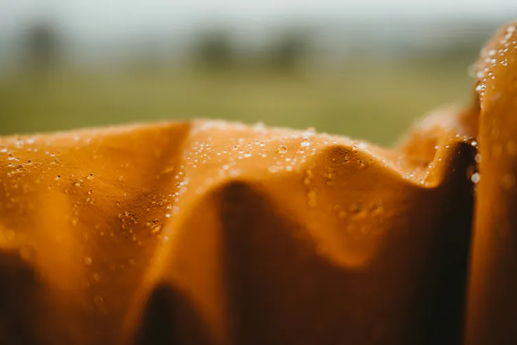 An orange fabric with droplets of water.