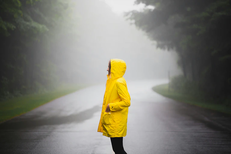 A person wearing a yellow jacket in the rain.