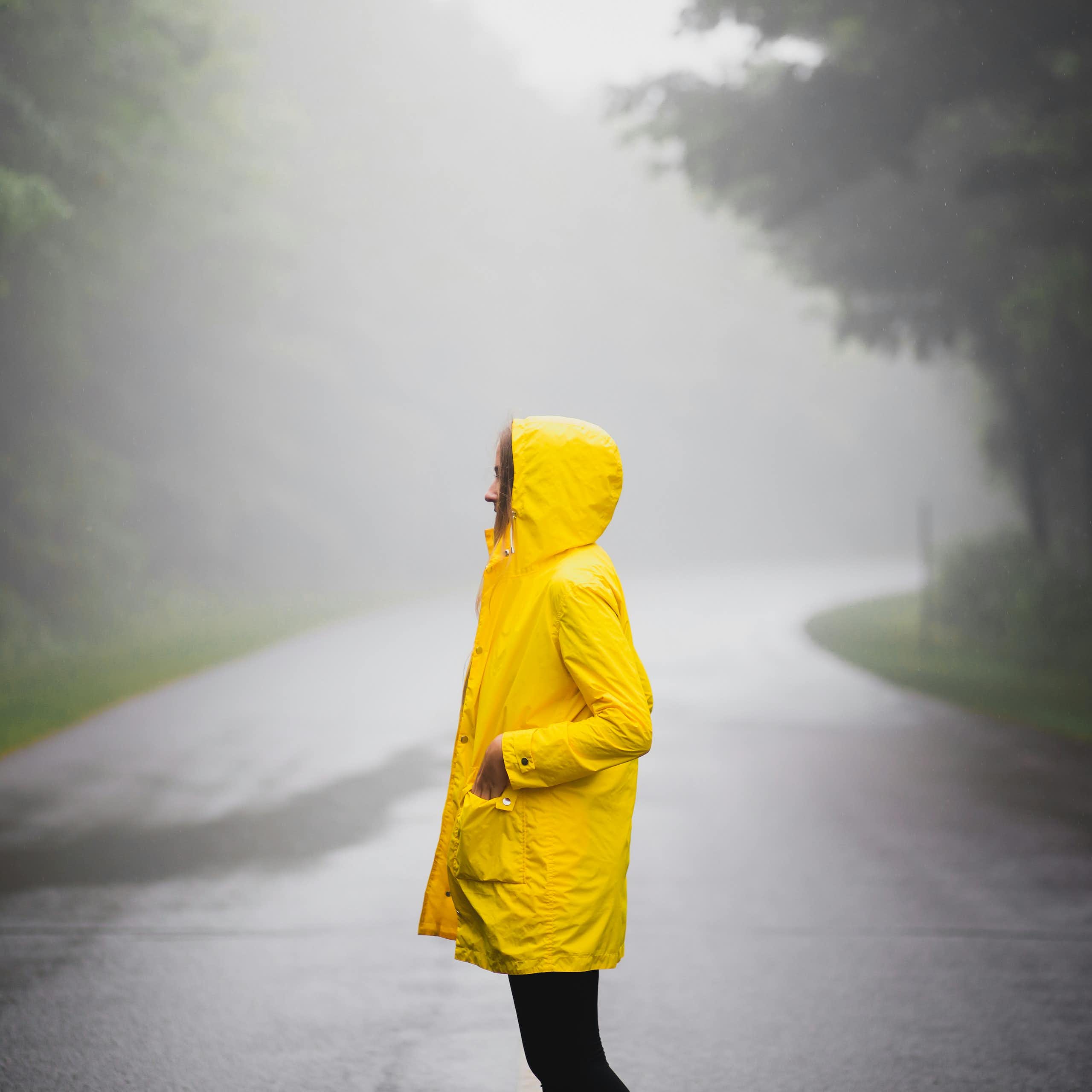 A person wearing a yellow jacket in the rain.
